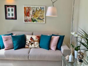 a couch with pillows on it in a living room at Villa Luminosa in Torre del Lago Puccini
