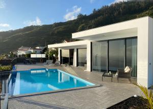 a house with a swimming pool in front of it at Moradia Syso in Arco da Calheta