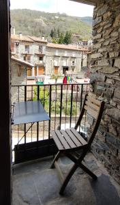 einen Holzstuhl auf einem Balkon mit einem Tisch in der Unterkunft cal dalmau apartaments loft in Pardines