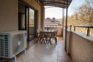 a balcony with a table and chairs and a heater at Bendida Central in Velingrad