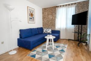 a blue couch in a living room with a table at Bendida Central in Velingrad