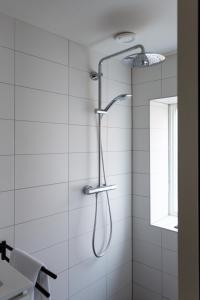een douche met een douchekop in de badkamer bij Hotel Markt23 in Sneek
