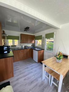 a large kitchen with a wooden table in a room at 92 Lake View in Caernarfon