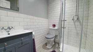 a bathroom with a toilet and a sink and a shower at Willows Apartment in Pitlochry +13 photos
