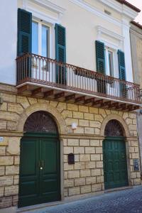 a building with two green doors and a balcony at BeB Cornelia in Atri