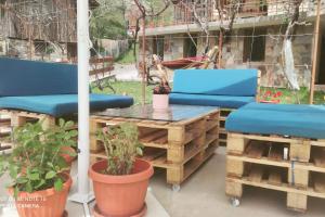 um pátio com 2 cadeiras azuis e uma mesa e cadeiras em Къща за гости Гаджакови em Devin
