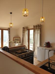 a kitchen with a stove and pendant lights at Mas del Roumany in Port-Vendres