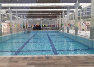 a large swimming pool with blue water in a building at Caesarea Sea View Suite in Caesarea