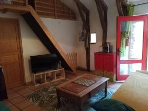a living room with a red door and a tv at la Fleur du MàS in Sablières