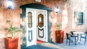 a door in a brick wall with a table and chairs at Bay & Basin in Sanctuary Point