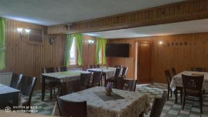 a dining room with tables and chairs and a flat screen tv at Къща за гости Гаджакови in Devin