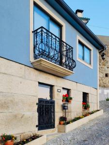 a building with a balcony and a door at dourobluehouse in Marco de Canavezes