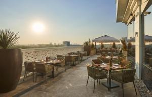 ein Restaurant mit Tischen und Stühlen auf einem Balkon in der Unterkunft Hyatt Regency Tashkent in Taschkent