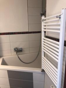 a bathroom with a bath tub with a hose at Vier Jahreszeiten 3-14 in Großenbrode