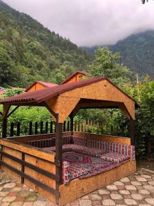 a wooden gazebo with a roof on a patio at şerah bungawilla in Uzungol
