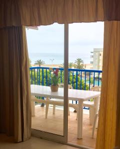 d'un balcon avec une table et une vue sur l'océan. dans l'établissement Apartamentos Palmavera, à Oropesa del Mar