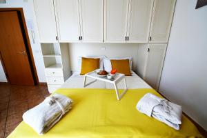 ein Schlafzimmer mit einem gelben Bett und einem Tisch darauf in der Unterkunft Residence Marlin in Riccione