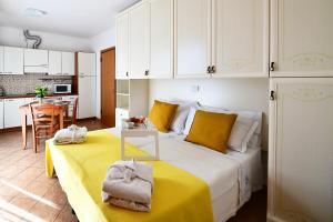ein Schlafzimmer mit einem Bett mit gelber Bettwäsche und weißen Schränken. in der Unterkunft Residence Marlin in Riccione
