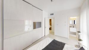 una sala de estar con paredes blancas y un espejo grande. en Luxury 3&4 Bedroom new apartments - close to the Beach & Bahai Gardens en Haifa