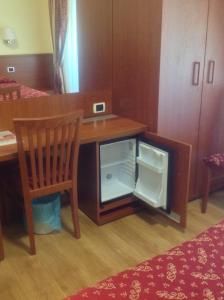 a wooden desk with an open refrigerator next to a chair at Guglielmo Marconi House in Rome
