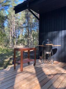 eine Holzterrasse mit einem Grill und einem Picknicktisch in der Unterkunft Kalana Virve Holiday Villa in Kalana