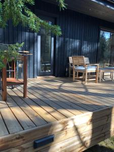 eine Holzterrasse mit einem Tisch und Stühlen darauf in der Unterkunft Kalana Virve Holiday Villa in Kalana