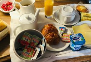 bandeja de desayuno con una bandeja de alimentos para el desayuno y café en Hôtel Le Stanislas, en Nancy