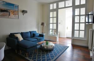 Hage的住宿－Friesischer Hof (Luftkurort)，客厅配有蓝色的沙发和桌子