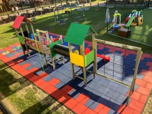 a playground with colorful play equipment in a park at Rezydencja Kwiatano - Basen & Jacuzzi & Sauna & Plac Zabaw in Grzybowo