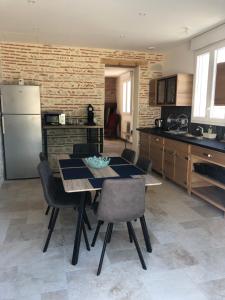 a kitchen with a table and chairs in a kitchen at Le Cottage de Romas in Villeneuve-sur-Lot