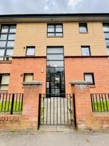 a brick building with a gate in front of it at Modern 2 bed Apartment Near City Centre in Glasgow