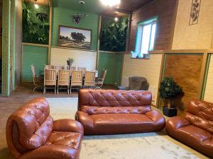 a living room with brown leather furniture and a table at Green Villa in Hora