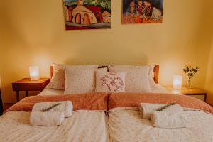 een slaapkamer met een groot bed met 2 lampen erop bij Villa Holiday Home Kuća za odmor Slavonka in Kaptol