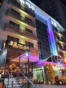 um edifício com um sinal em frente em New Jeju Hotel em Jeju