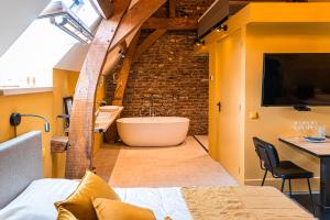 een badkamer met een bad, een bed en een tafel bij B&B Kasteel Limbricht in Limbricht