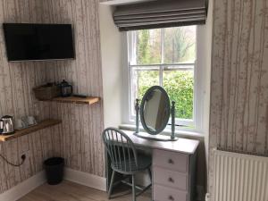a mirror on a desk in a room with a window at Summerhill Guest House in Betws-y-coed