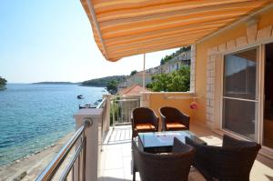 a balcony with chairs and a table and a view of the water at Apartments Korčula in Prizba