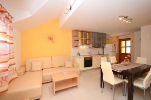 a living room and kitchen with a couch and a table at Apartments Korčula in Prizba