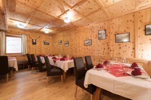 a dining room with tables and chairs and wooden walls at Hotel Gabl by Alpeffect Hotels in Sankt Anton am Arlberg
