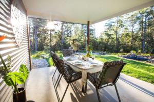 a dining table and chairs on a patio at Dorrigo Bush Pepper Retreat in Deer Vale