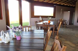 a dining room with a wooden table and chairs at Cataguás Brasil Pousada in Carrancas