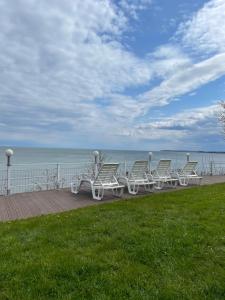 een rij stoelen op een promenade bij de oceaan bij Eugen Apartments in Swarzewo