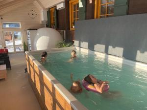 eine Gruppe von Personen, die in einem Schwimmbad schwimmen in der Unterkunft Penzion Haltmar in Ostružná