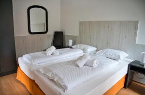 two beds in a room with white towels on them at GRASSEGGER APPARTEMENTHAUS in Sankt Johann am Tauern