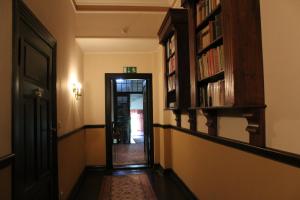 a hallway with a door and a book shelf with books at Gutshaus Kubbelkow in Bergen auf Rügen