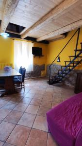 a living room with a table and a spiral staircase at Casa Beatrice in Bolsena