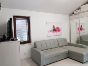 a living room with a couch and a television at Relax Zone III in Malinska