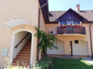 Casa con escalera y balcón con flores en Galery Apartman, en Gyula