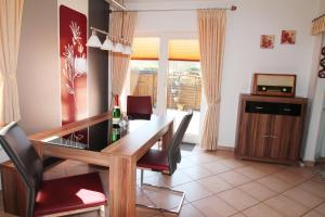 a dining room with a table and chairs and a television at Haus Clara in Husby