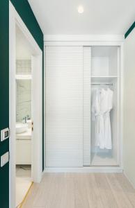 a bathroom with a sliding glass door with a robe at Original Boutique Hotel in Tbilisi City +37 photos